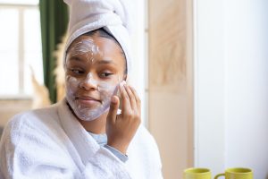 Girl in a White Bathrobe Applying Face Cream